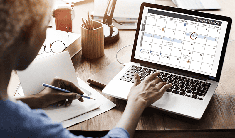Person planning a calendar on a laptop