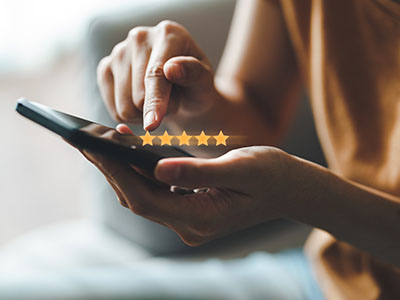 Person on a mobile phone using Let’s Talk for district communications with five stars representing the rating.